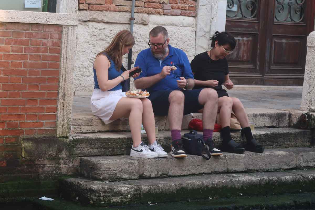 tourists eating cicchetti venice